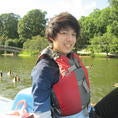 Shot of Kenneth from waist up, in a boat on a lake, smiling at camera to his right