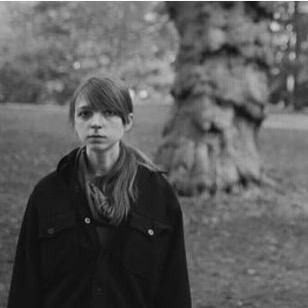 Black-and-white photo of Kristen standing in front of a tree