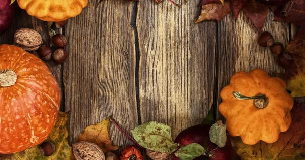 Aerial view of a wooden table with pumpkins and fall leaves