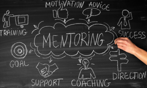 Mentoring written on a chalkboard inside an idea cloud with arrows pointing to other ideas outside the cloud