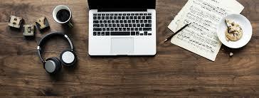 A desk with computer, paper, and coffee